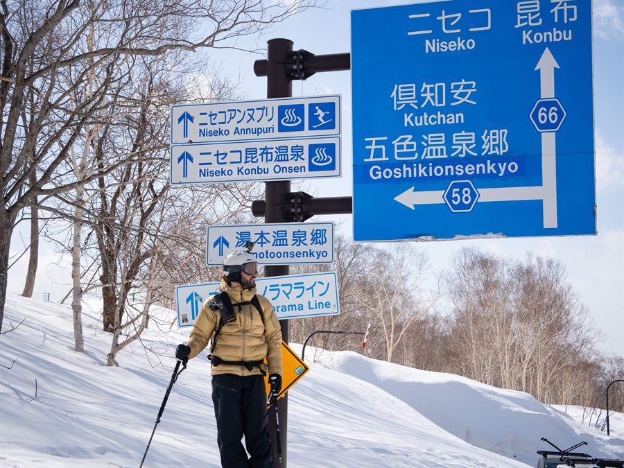 Skier beside Japanese road signs
