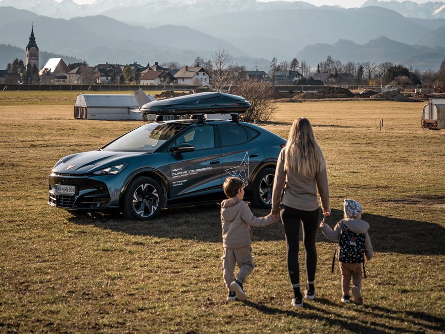 A family beside their car in a meadow