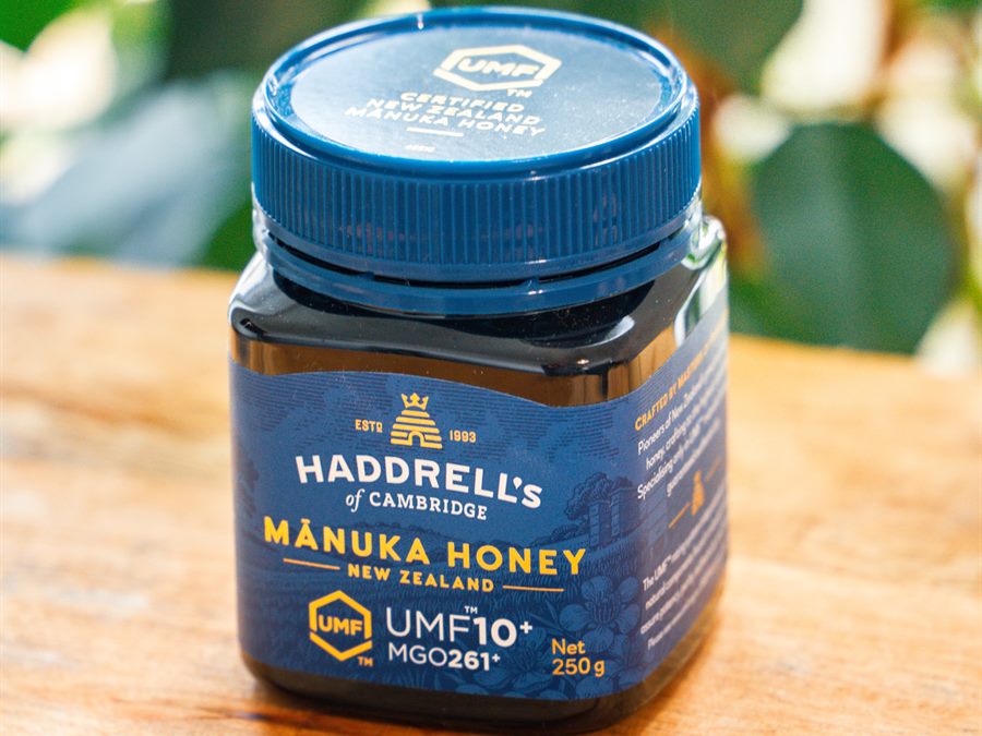 A jar of manuka honey on a wooden table