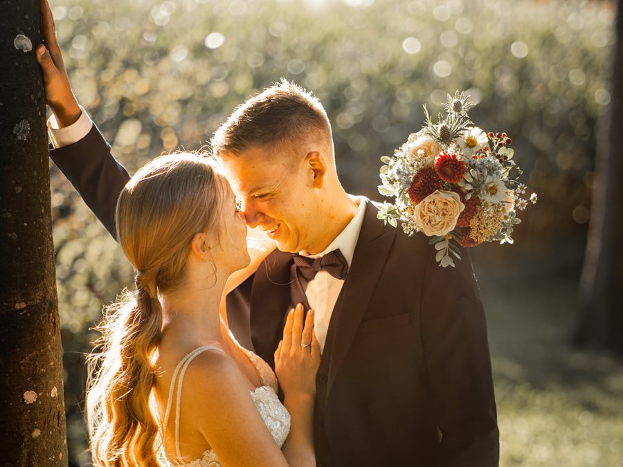 An embrace in evening light, bouquet in hand