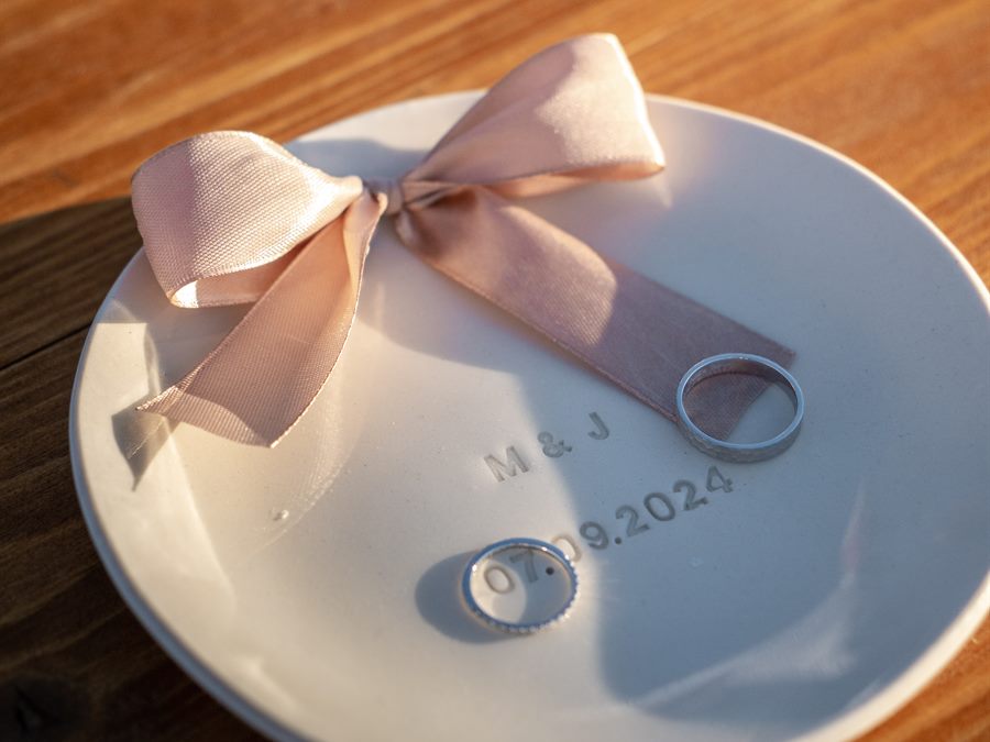 The wedding rings on a plate with a ribbon