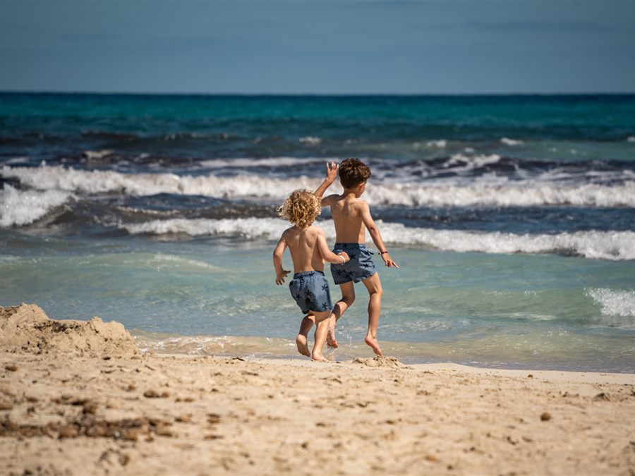 Two children running into the sea