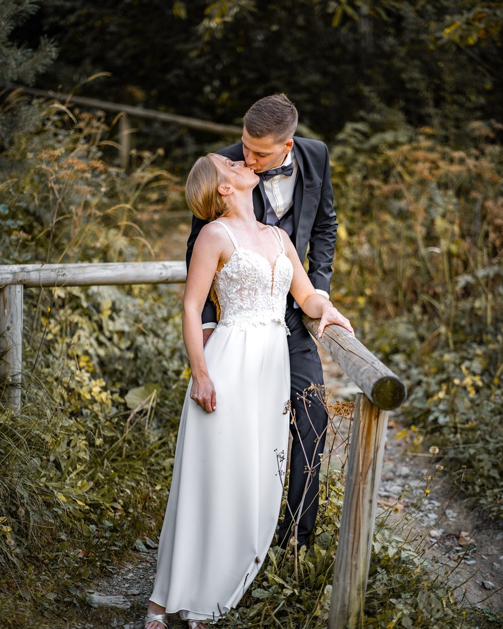 Bride and groom by a wooden railing