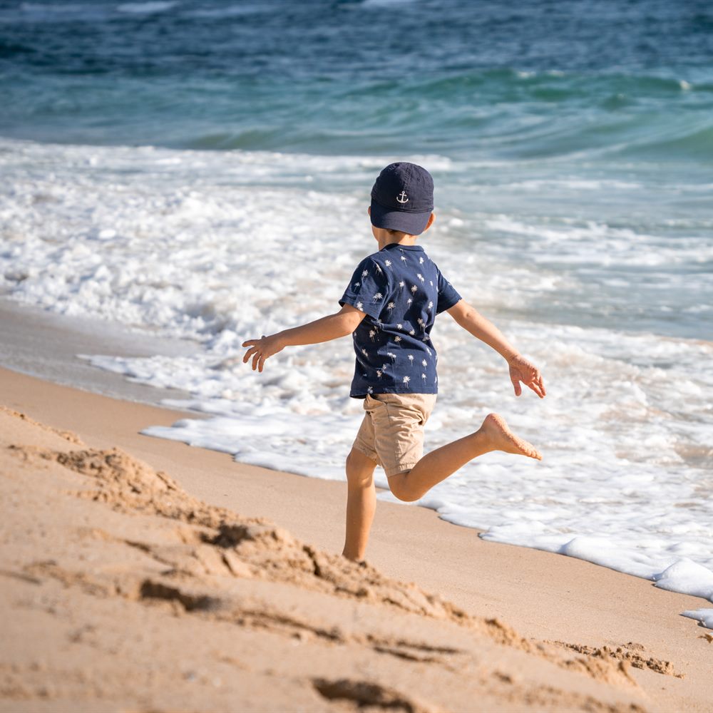 A boy running along the shore