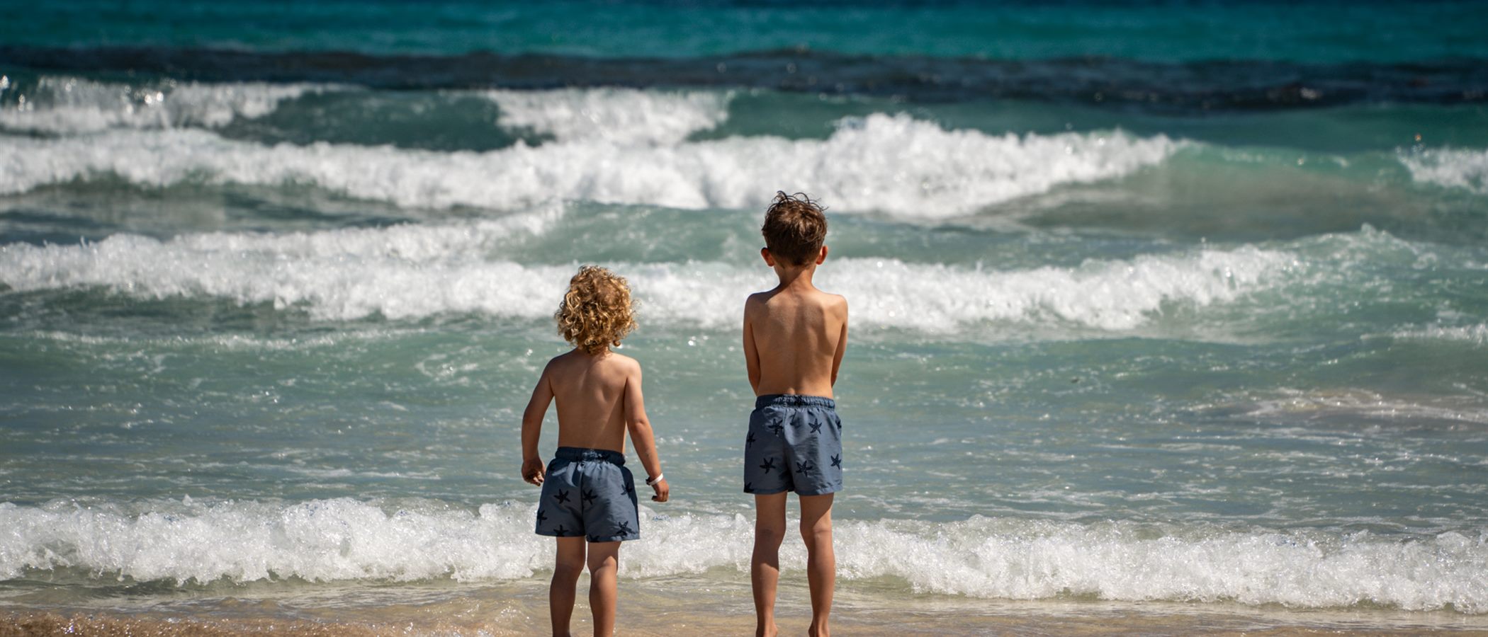 Two children at the sea, wide frame